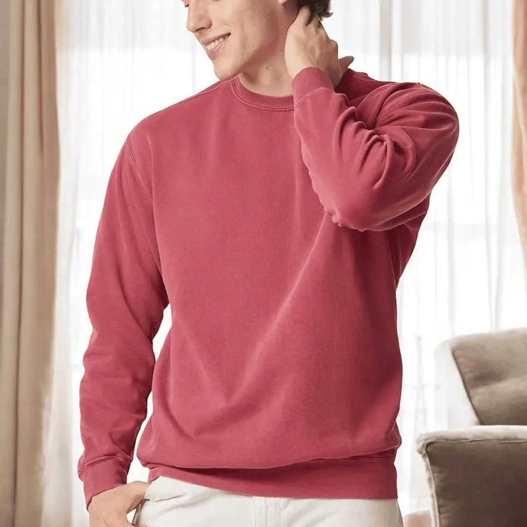Person wearing a red sweatshirt in a neutral indoor setting